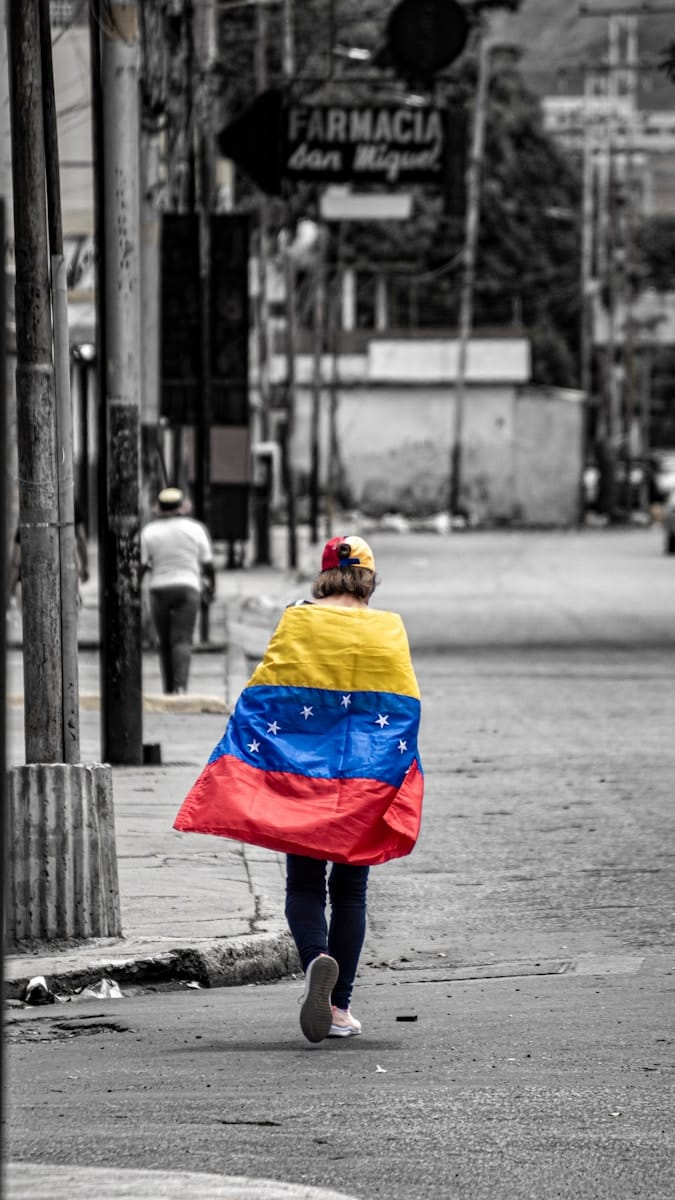 A person walking down a street holding a flag
